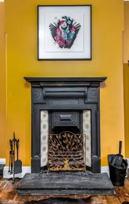 a fireplace in a room with a picture on the wall at Tranquil Glasgow Retreat in Glasgow