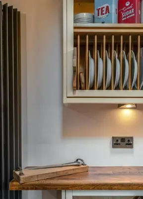 a kitchen counter with a cupboard with utensils at Tranquil Glasgow Retreat in Glasgow