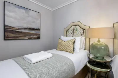 a bedroom with two beds and a painting on the wall at Ledi Lookout Callander in Stirling