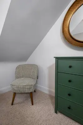 a bedroom with a dresser and a chair and a mirror at Ledi Lookout Callander in Stirling