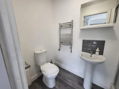 a white bathroom with a toilet and a sink at Fishpond Family Suite in Moffat