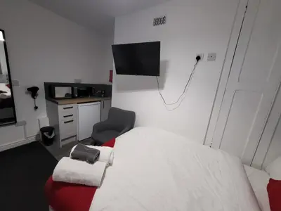 a bedroom with a bed and a tv on the wall at Fishpond Family Suite in Moffat