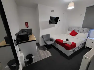 a bedroom with a bed and a desk and a television at Fishpond Family Suite in Moffat