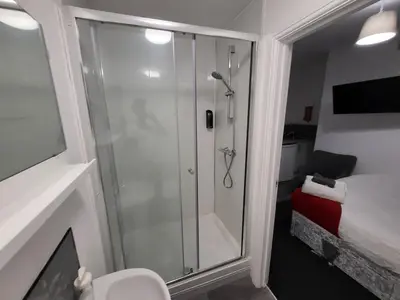 a bathroom with a shower with a glass door at Fishpond Family Suite in Moffat