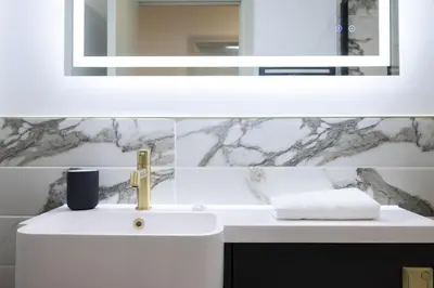 a bathroom with a white sink and a mirror at Luxury Flat Near Hove Station parking sleeps 4 in Moffat