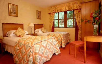 a hotel room with two beds and a window at Macdonald Forest Hills Resort in Aberfoyle