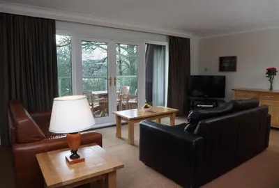 a living room with a couch and chairs and a table at Macdonald Forest Hills Resort in Aberfoyle