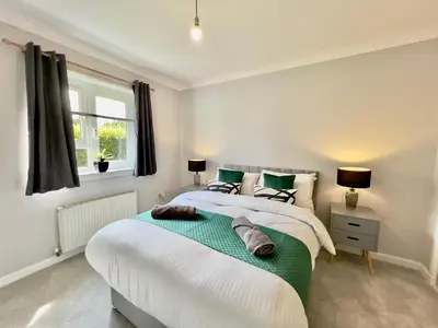 a bedroom with two beds and a window at Stylish City Apartment with Free Parking near Town in Glasgow