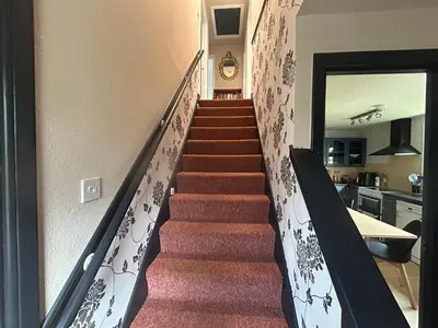 a staircase in a home with red carpeting and a stair case at 29 Carnoch, Glencoe Village in Glencoe