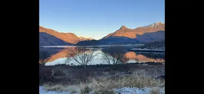 a view of a lake in front of some mountains at 29 Carnoch, Glencoe Village in Glencoe