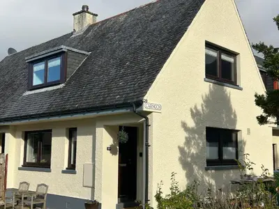 a white house with a black roof at 29 Carnoch, Glencoe Village in Glencoe
