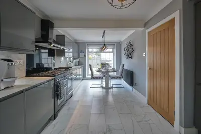 a kitchen with a table in the middle of a room at Stay Torrance-Village Home Near Glasgow in Glasgow