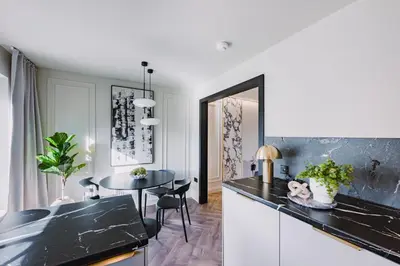 a kitchen with a black counter top and a table at JW Executive ApartHouse 2 in Glasgow