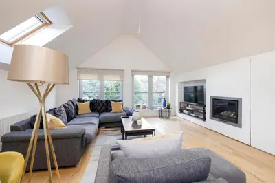 a living room with a couch and a tv at Chic Edinburgh 3-Bedroom 2-Storey House near City Centre with Free Parking in Edinburgh
