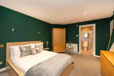 a bedroom with a large bed with green walls at Chic Edinburgh 3-Bedroom 2-Storey House near City Centre with Free Parking in Edinburgh