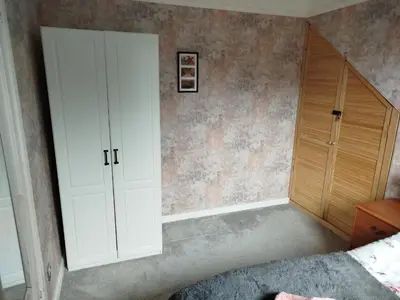 a bedroom with a white cabinet and a bed at Lovely place at Stenhouse in Edinburgh