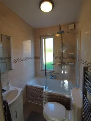 a bathroom with a tub and a toilet and a sink at Lovely place at Stenhouse in Edinburgh