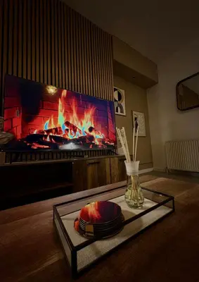 a living room with a fireplace and a tv at Cozy corner-Sleeps 8 guest Entire house Glasgow very central in Glasgow