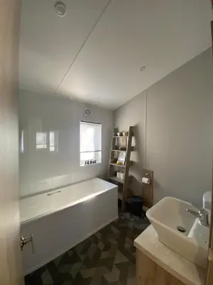 a bathroom with a large white tub and a sink at Wemyss Bay Mapleton Elite in Wemyss Bay
