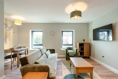 a living room with a couch and a table at Stunning upper villa stay in the City! in Edinburgh