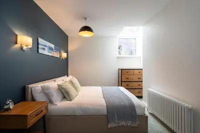 a small bedroom with a bed and a dresser at Stunning upper villa stay in the City! in Edinburgh