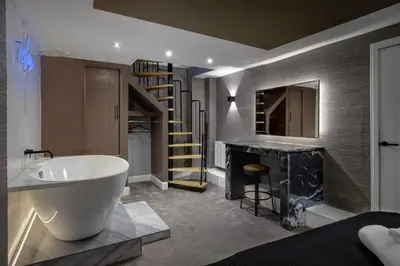 a bathroom with a large bath tub and a staircase at Stylish Edinburgh Apartment in Edinburgh