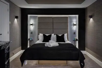 a bedroom with a large bed with a large headboard at Stylish Edinburgh Apartment in Edinburgh