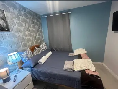 a bedroom with a bed with blue walls at Stylish 3 bedroom house in Glasgow