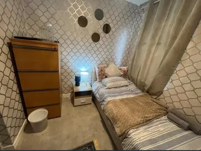 a small bedroom with a bed and a dresser at Stylish 3 bedroom house in Glasgow