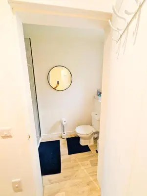 a bathroom with a toilet and a mirror on the wall at YSquared studio in Falkirk