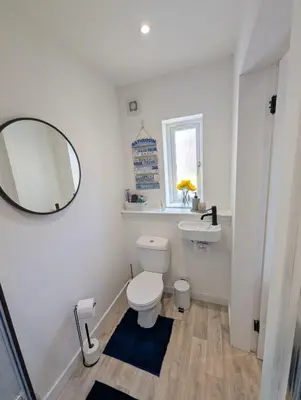 a bathroom with a white toilet and a mirror at YSquared studio in Falkirk