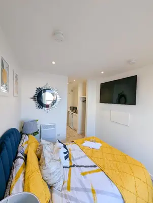 a bedroom with a bed with a laptop on it at YSquared studio in Falkirk