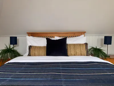 a large bed with black and white sheets and pillows at Upstairs at Carlingford in Newton Mearns