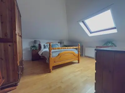 a bedroom with a bed and a skylight at Upstairs at Carlingford in Newton Mearns