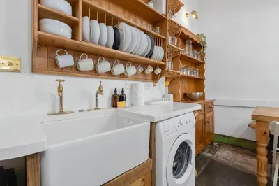 a kitchen with a sink and a washing machine at Charming Central Stay in Moffat