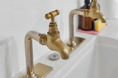 a bathroom sink with two brass faucets at Charming Central Stay in Moffat