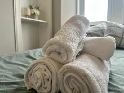 a rolled up towel sitting on top of a bed at Appin Apartments - Welcome to a delightful and cozy one bedroom flat in Glasgow
