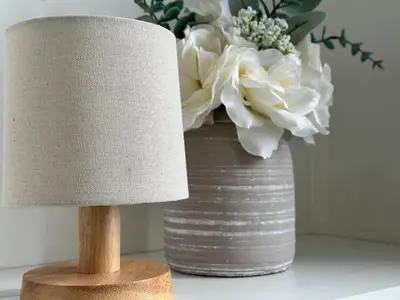 a lamp and a vase with flowers on a table at Appin Apartments - Welcome to a delightful and cozy one bedroom flat in Glasgow