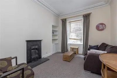 a living room with a couch and a fireplace at 3 Bedrooms Flat in Central Edinburgh New Town , Lothian Road in Edinburgh