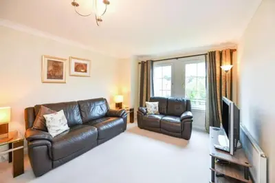 a living room with a leather couch and a television at Amazing Apartment by The Wallace Monument in Stirling
