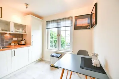 a kitchen with white cabinets and a table and a window at Amazing Apartment by The Wallace Monument in Stirling