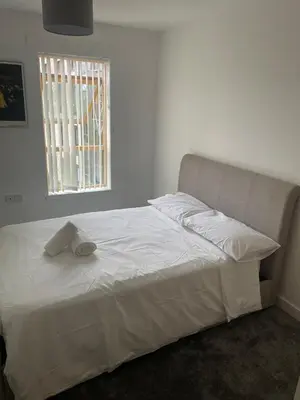a white bed in a bedroom with a window at Maison 109 Suite - Modern City Apartment in Glasgow