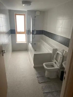 a bathroom with a tub and a toilet and a sink at Maison 109 Suite - Modern City Apartment in Glasgow