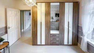 a room with a closet with a wooden door at Quite and new Glasgow house, Commore Drive in Drumchapel
