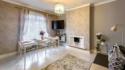 a living room with a table and chairs and a fireplace at Quite and new Glasgow house, Commore Drive in Drumchapel