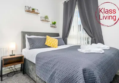 a bedroom with a bed and a window at Lady Wilson Apartment by Klass Living Airdrie in Airdrie