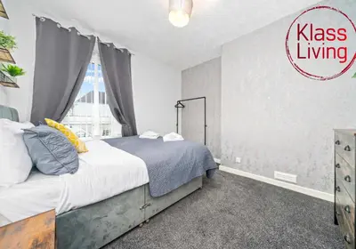 a bedroom with a bed and a large window at Lady Wilson Apartment by Klass Living Airdrie in Airdrie
