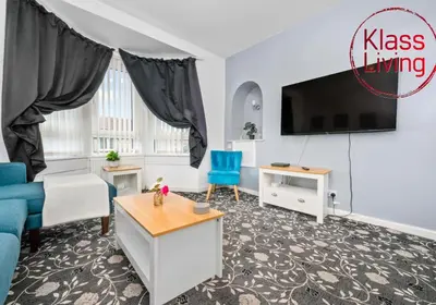 a living room with a couch and a tv at Lady Wilson Apartment by Klass Living Airdrie in Airdrie