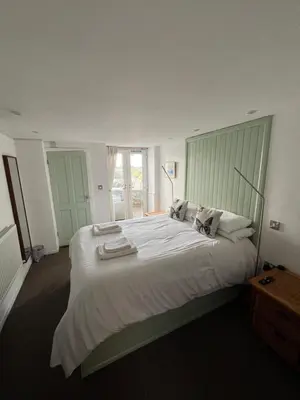 a large white bed in a room with a window at Old Brewery Cottage - Ellenabeich, Easdale - Isle of Seil