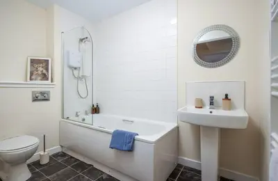 a bathroom with a tub and a sink and a toilet at 2BR Apartment with Parking Near Southside and Queens Park in Mansewood
